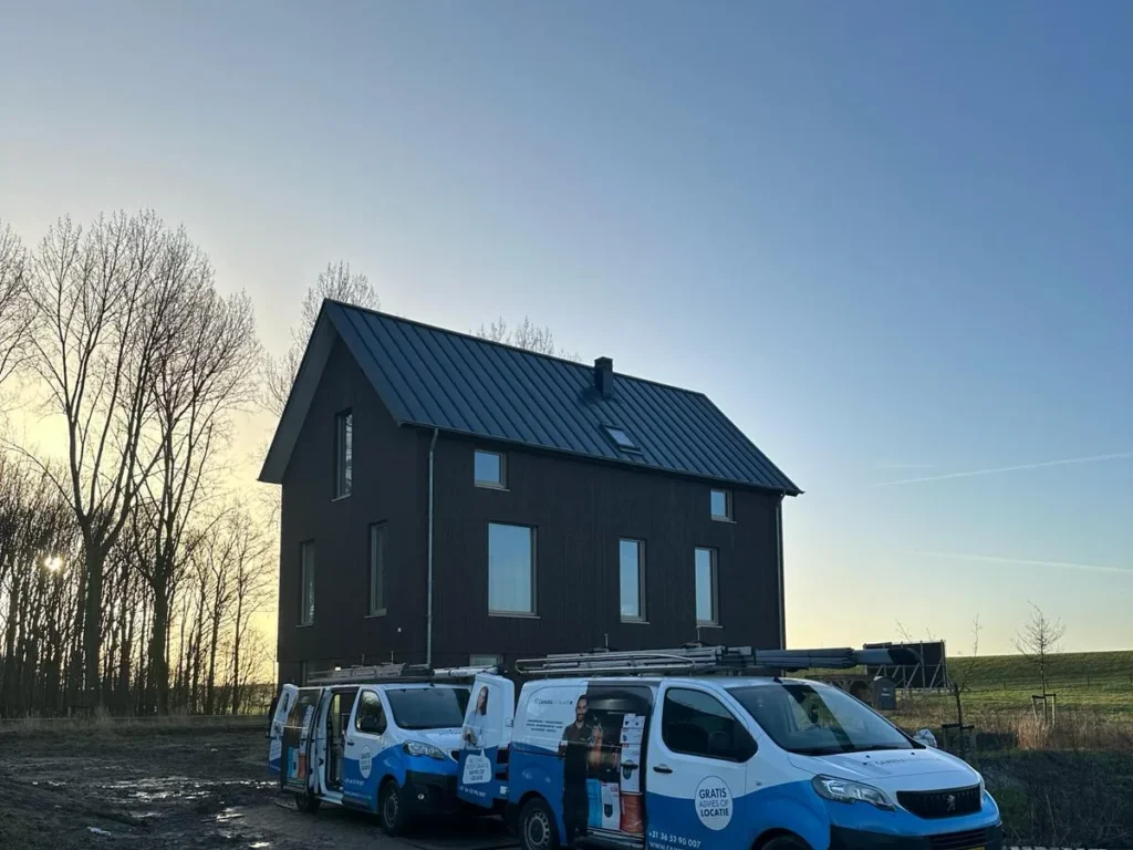 Twee bedrijfsbussen op locatie bij een woning aan het eind van de werkdag