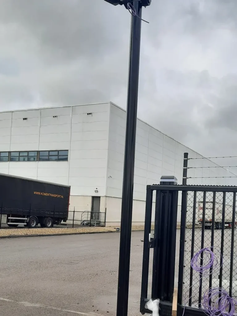Camerapaal bij de poort van een bedrijfsterrein