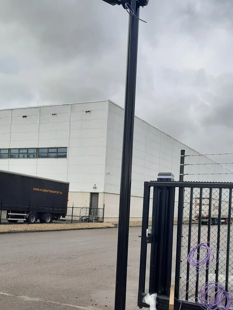 Camerapaal bij de poort van een bedrijfsterrein