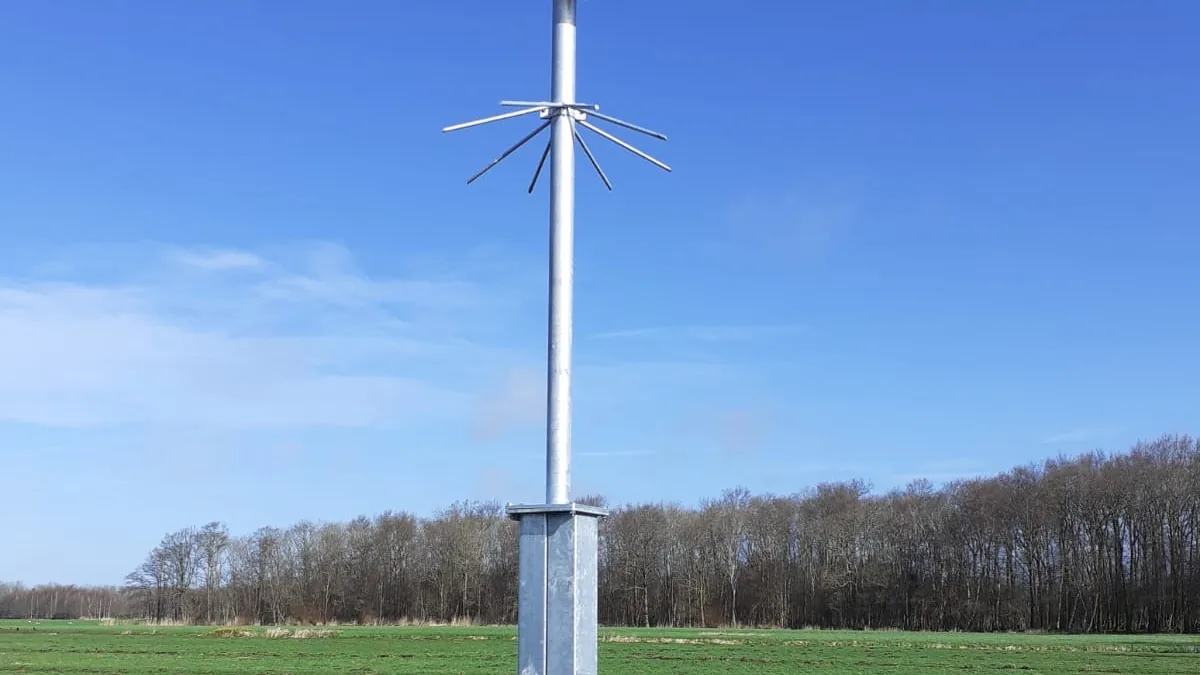 Verzinkte camerapaal in een weiland in het buitengebied