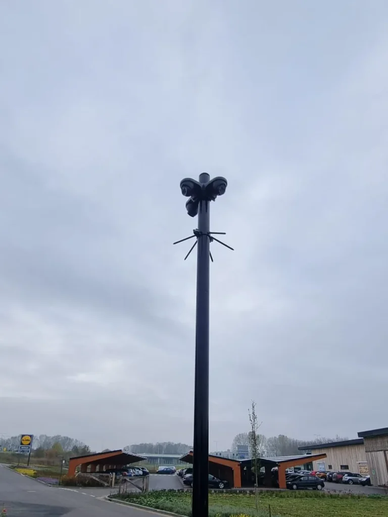 Zwarte camerapaal langs een doorgaande weg buiten de bebouwde kom