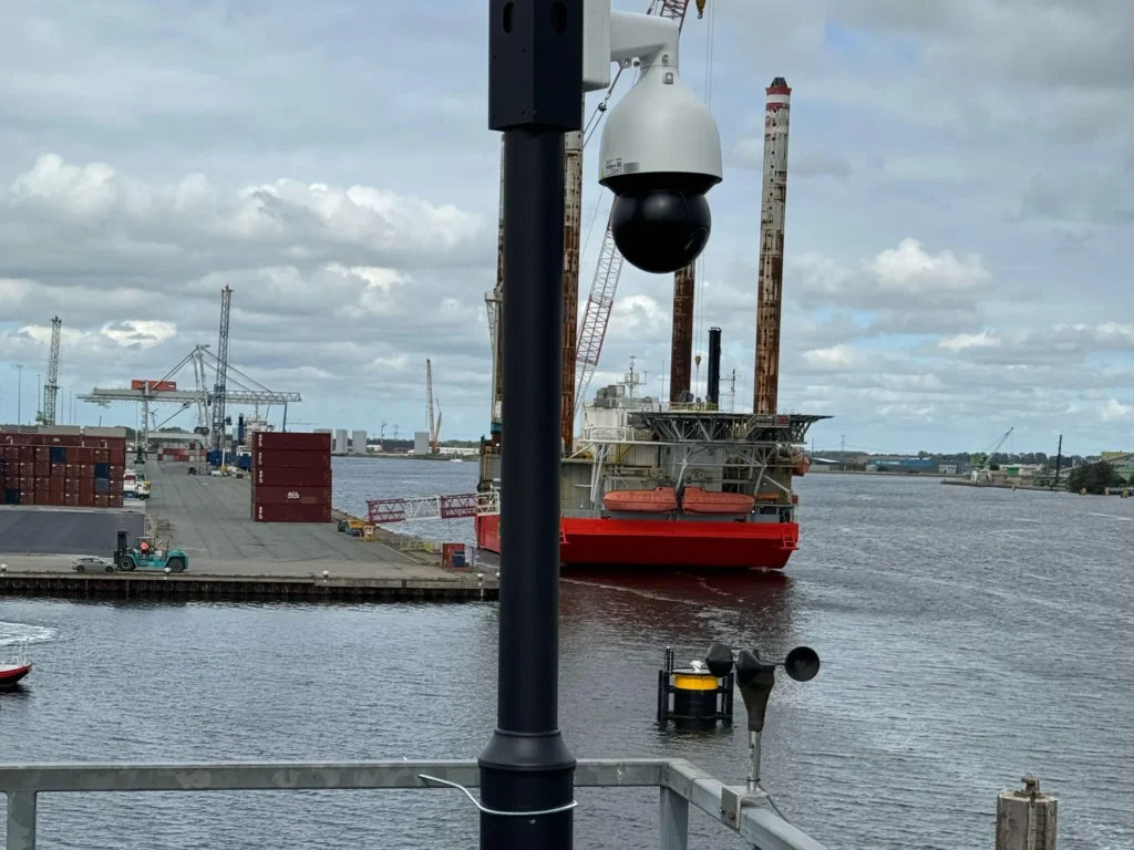 Camerapaal met een draaibare camera aan het water, met zicht over de kade