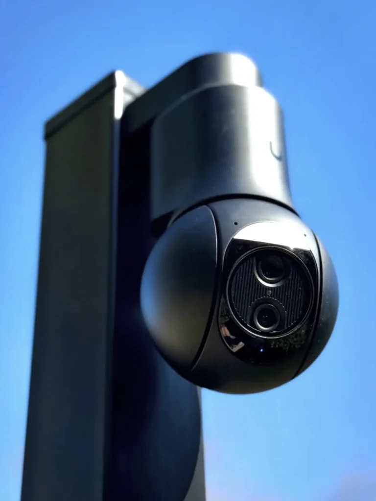 Draaibare camera op een zwarte paal tegen een blauwe lucht