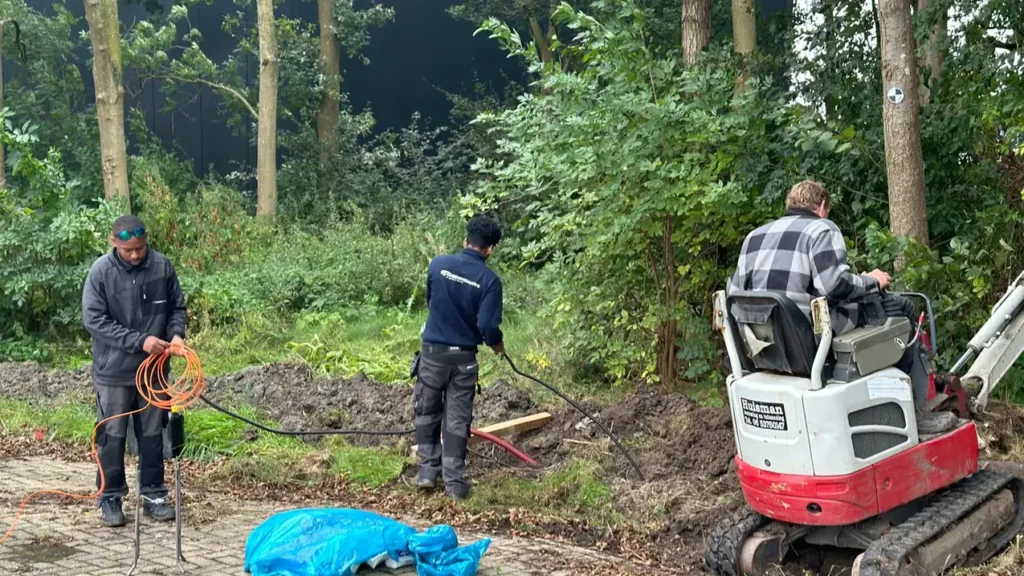 Graafwerk met een minigraver tussen de bomen, met zo min mogelijk schade aan de beplanting