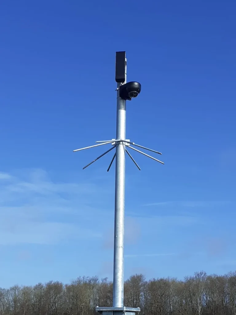 Hoge camerapaal die boven de bomen uitkomt