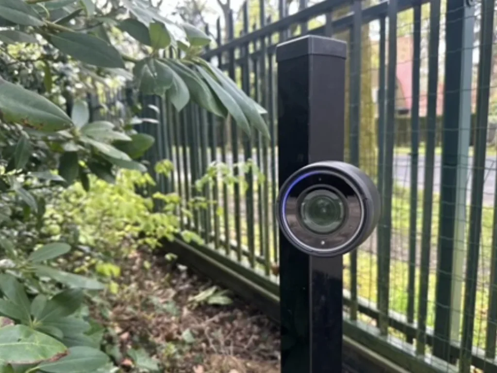 Laag zwart camerapaaltje bij de inrit, met de camera recht op de rijrichting