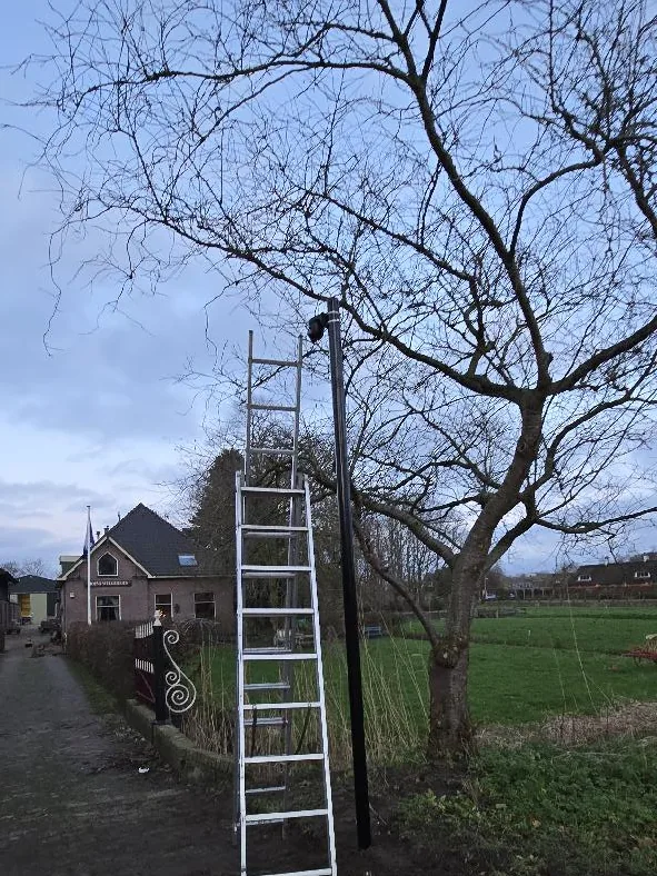 Ladder tegen de paal tijdens de montage van de camera