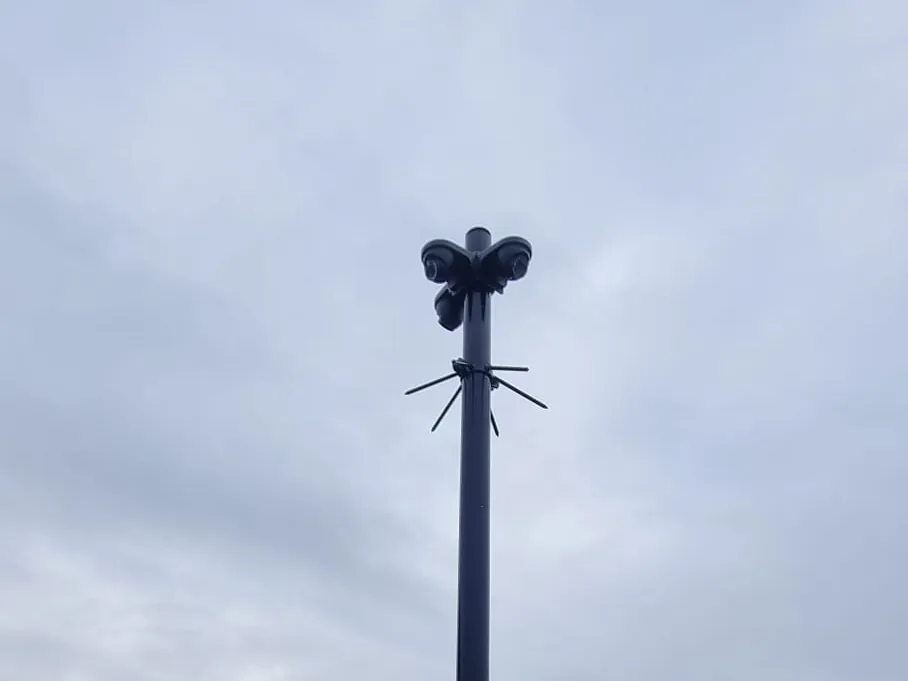 Net geplaatste camerapaal op een bedrijfsterrein, met het grondwerk er nog omheen