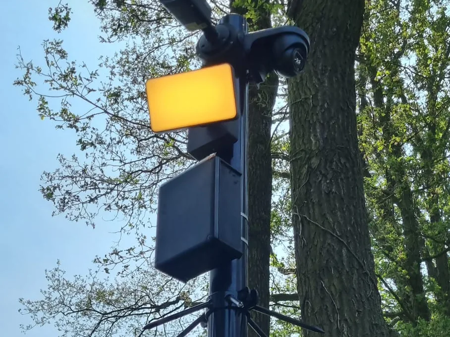 De kop van de paal van dichtbij, met de camera en de verlichting naast elkaar
