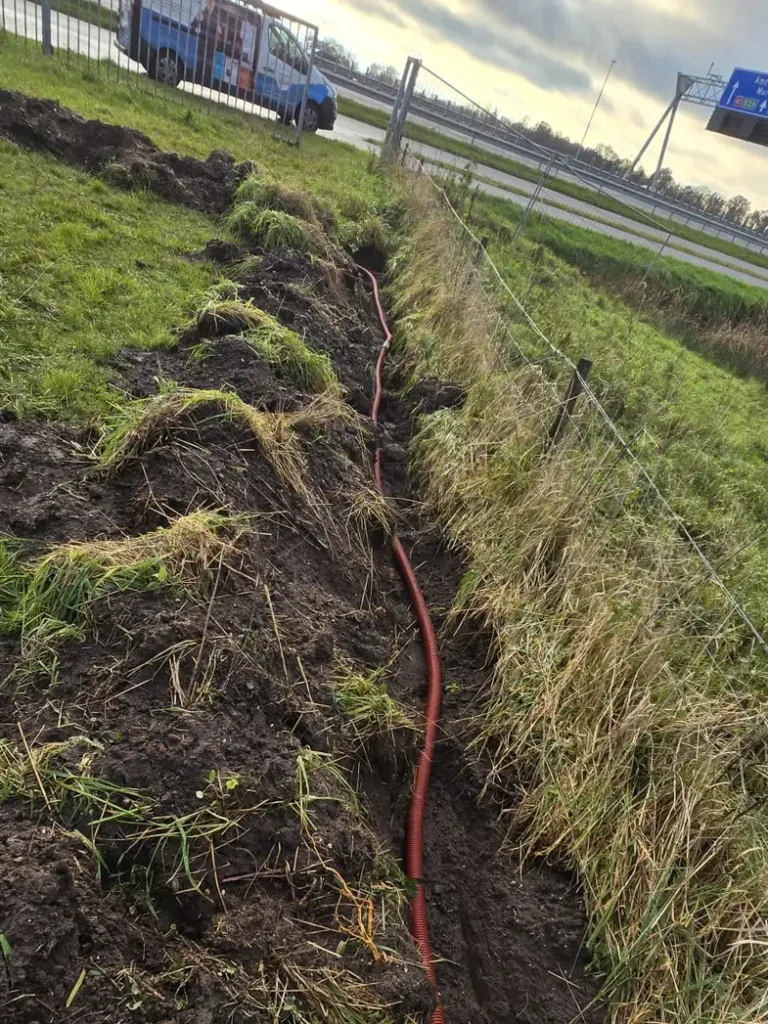 Sleuf met de mantelbuis erin, langs de weg naar de plek van de paal