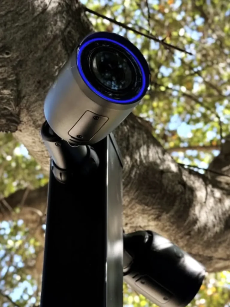 Twee camera’s op een paal tussen de bomen, elk een andere kant op