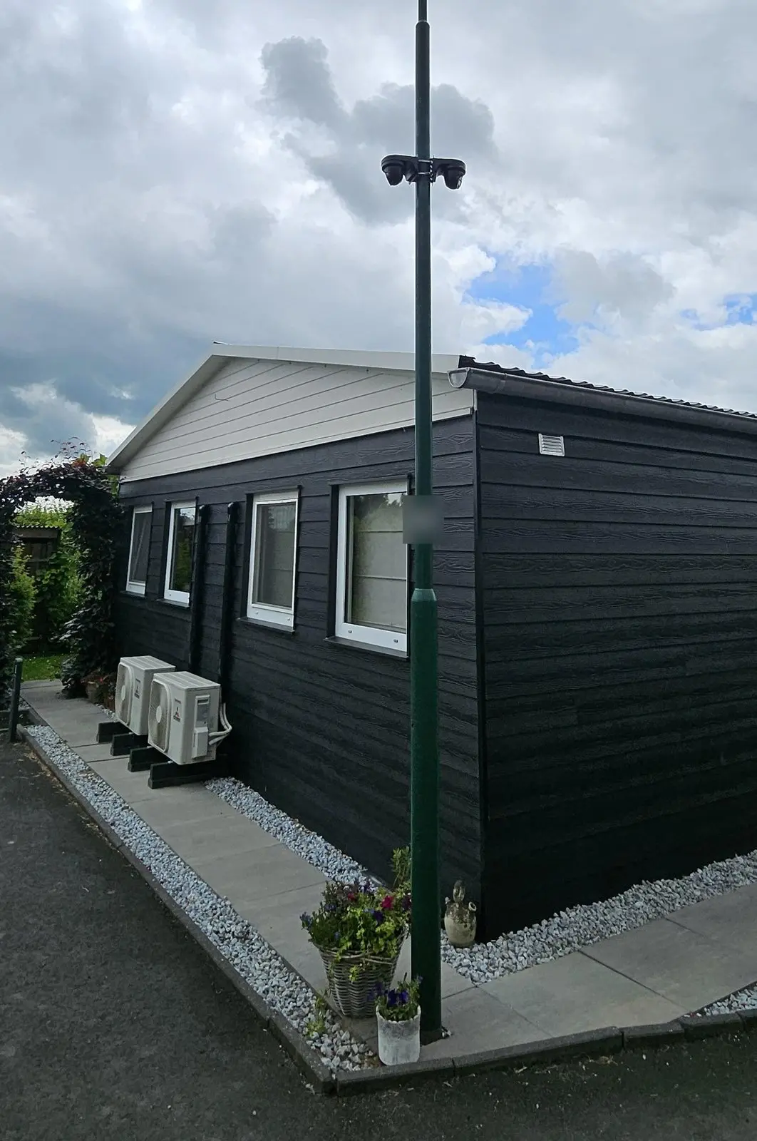 Mast met twee camera’s bij een zorgwoning op een erf