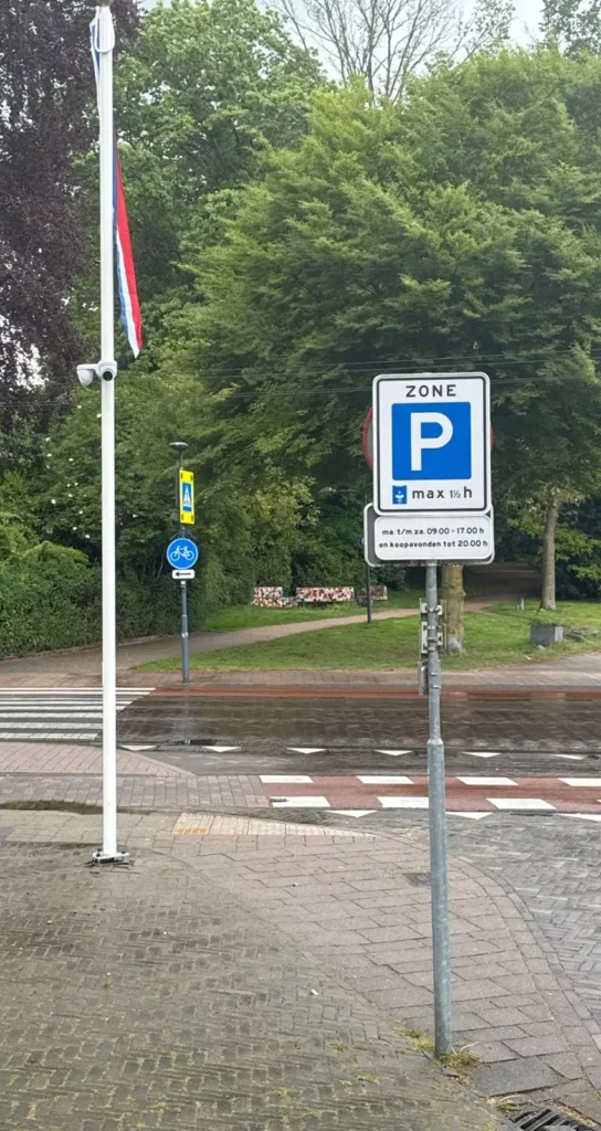 Witte vlaggenmast met camera op een straathoek