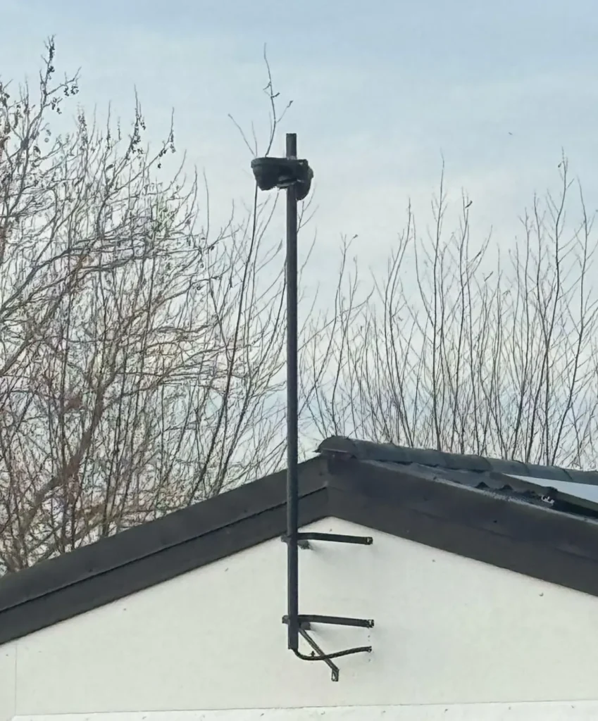 Paal met beugels aan de nok van de schuur