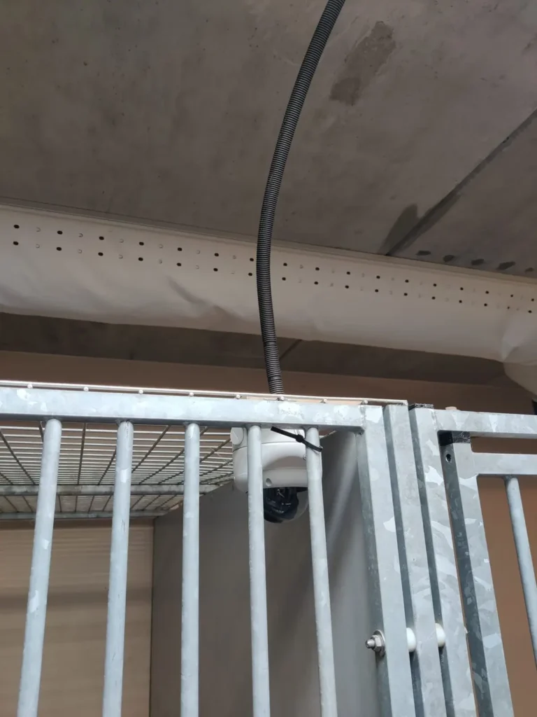 Camera boven een kennel met de kabel in flexbuis
